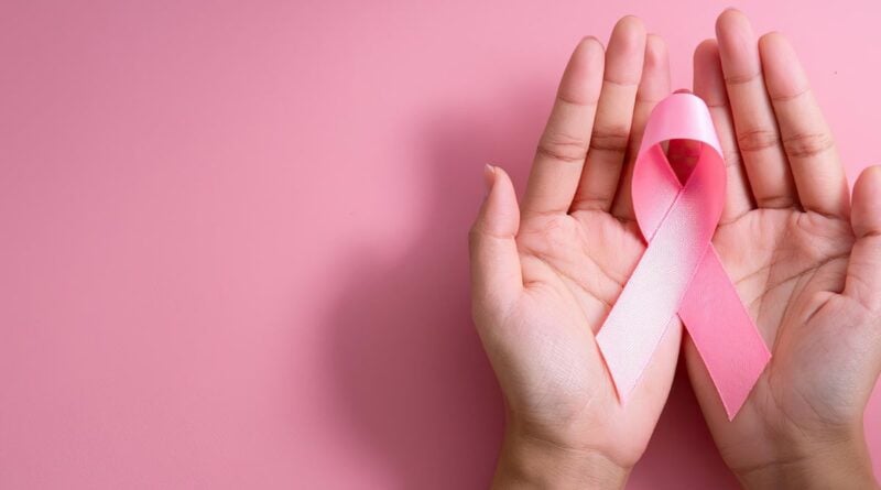 deux mains de femme ouverte avec un ruban rose à l'intérieur sur un fond rose