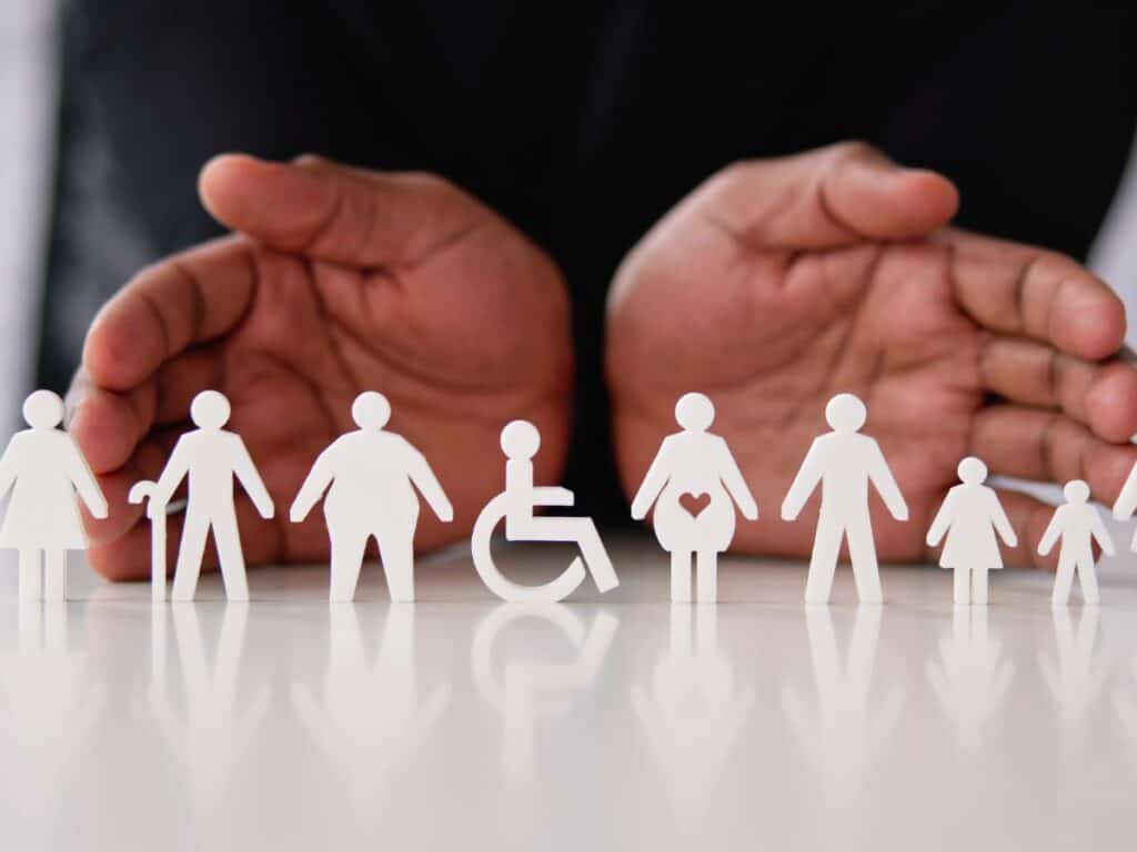 Deux mains ouvertes sur des figurines handicapées
